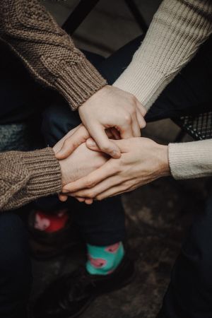 two people holding hands in a caring way, indoors